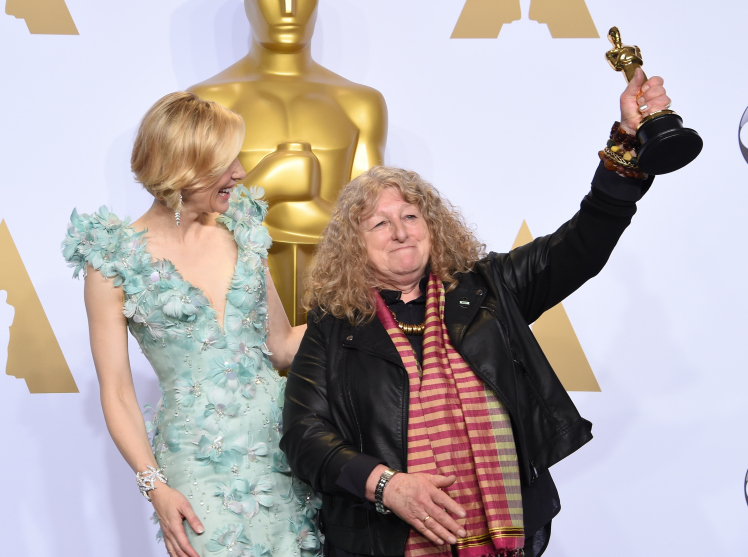 Actress Cate Blanchett (L) watches as Jenny Beavan celebrates with her Oscar for Best Costume Design, "Mad Max: Fury Road," in the press room during the 88th Oscars in Hollywood on February 28, 2016. AFP PHOTO/FREDERIC J. BROWN / AFP / FREDERIC J. BROWN (Photo credit should read FREDERIC J. BROWN/AFP/Getty Images)